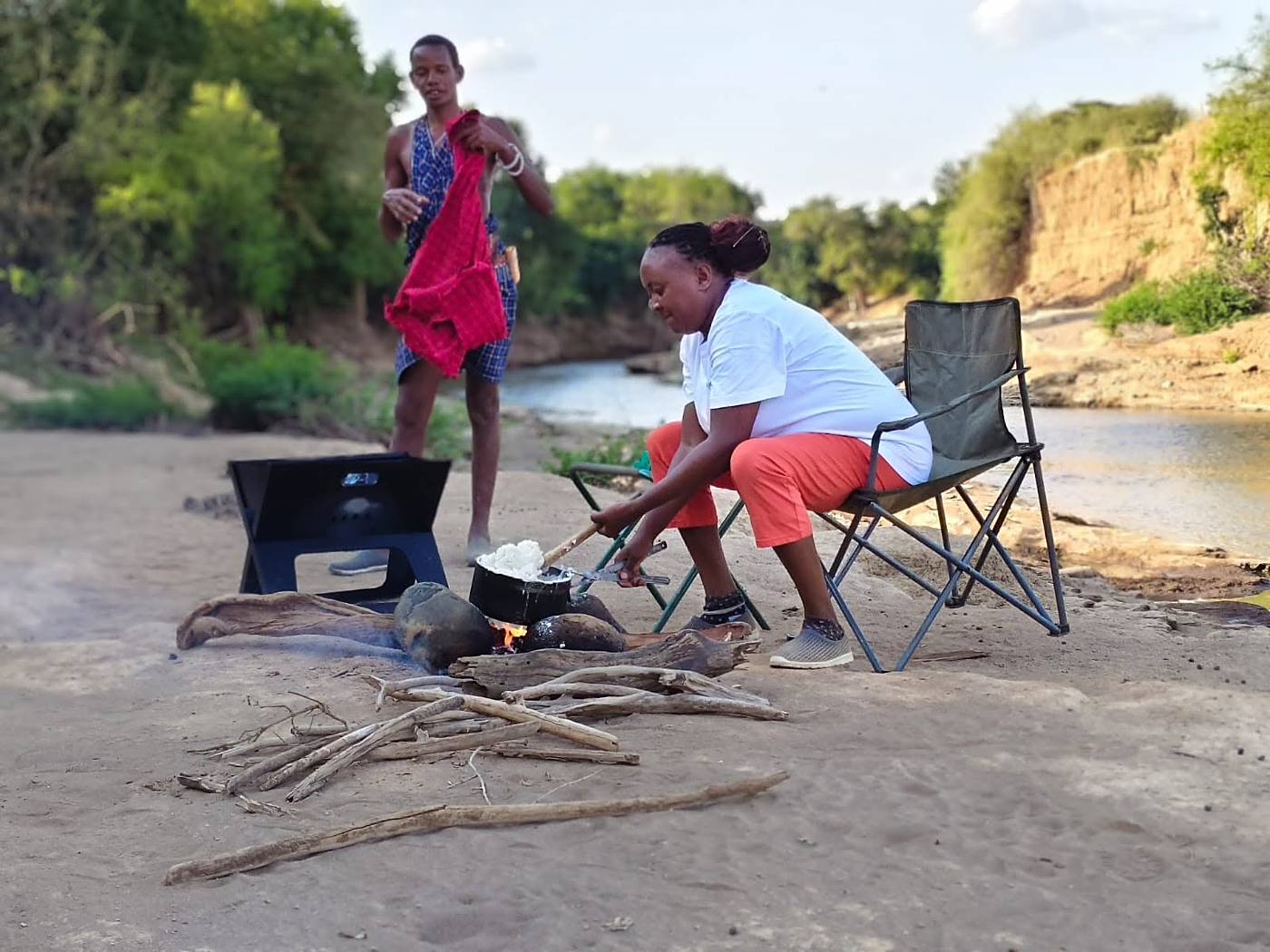 Cooking over an open fire on a sandbank beside the river