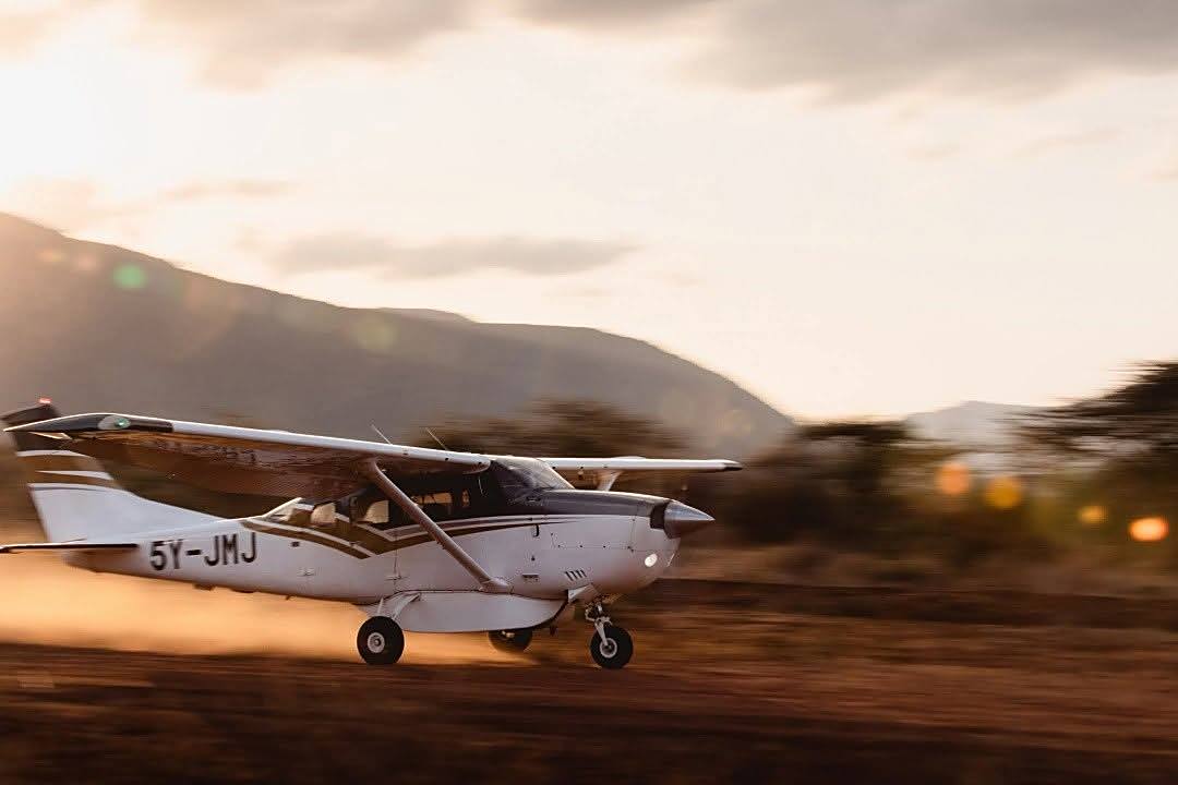 Small charter plane landing on the airstrip at sunset