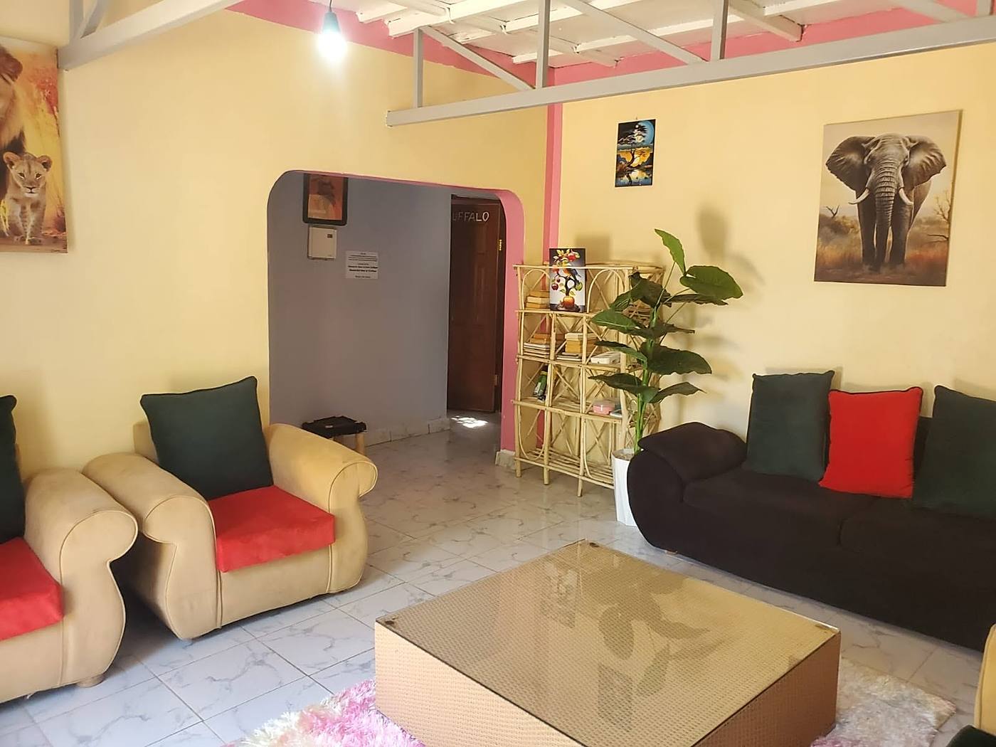 Guest lounge with armchairs, a coffee table and wildlife prints on the wall