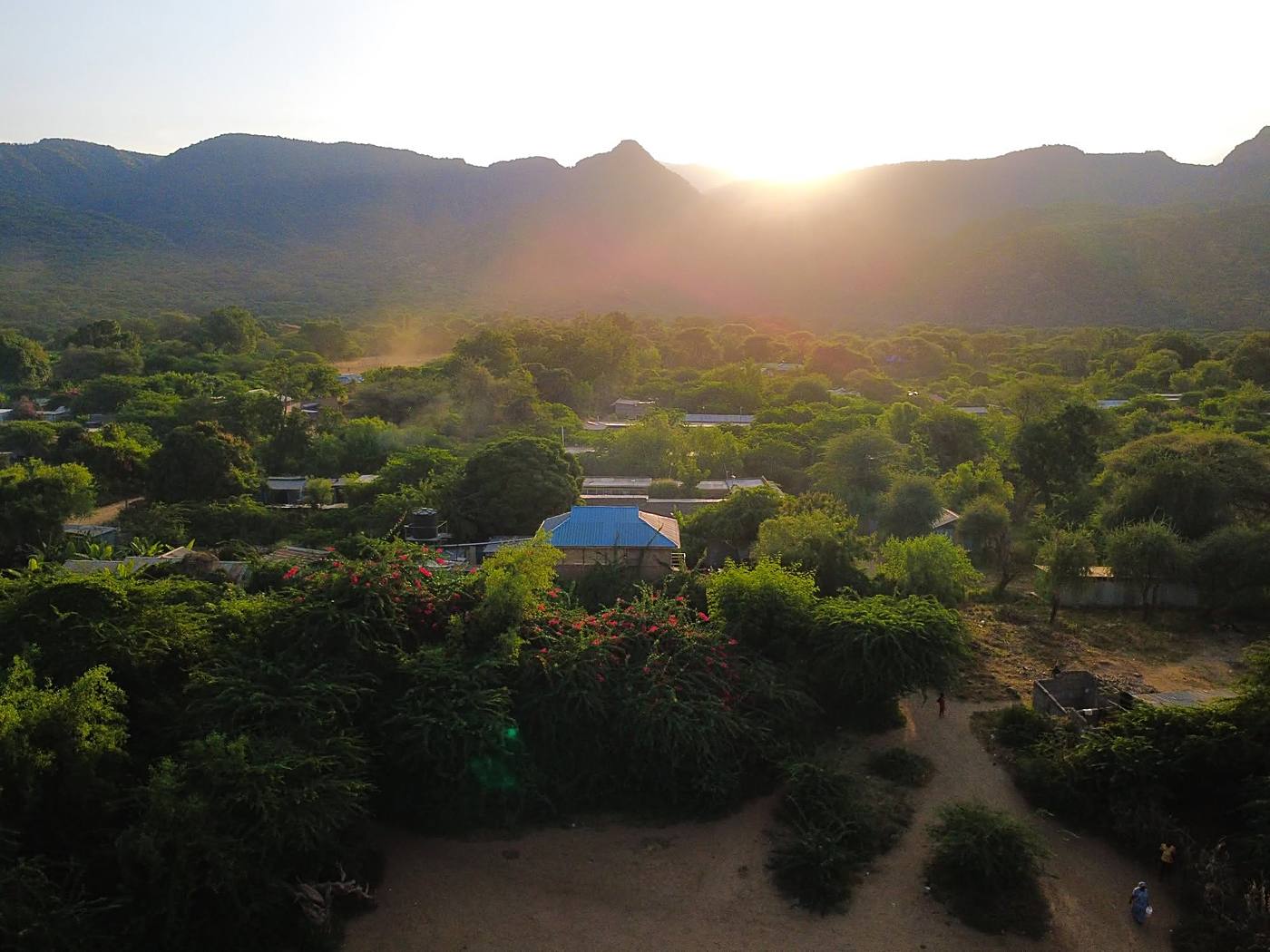 Aerial view of the resort and surrounding village at sunset beneath the escarpment
